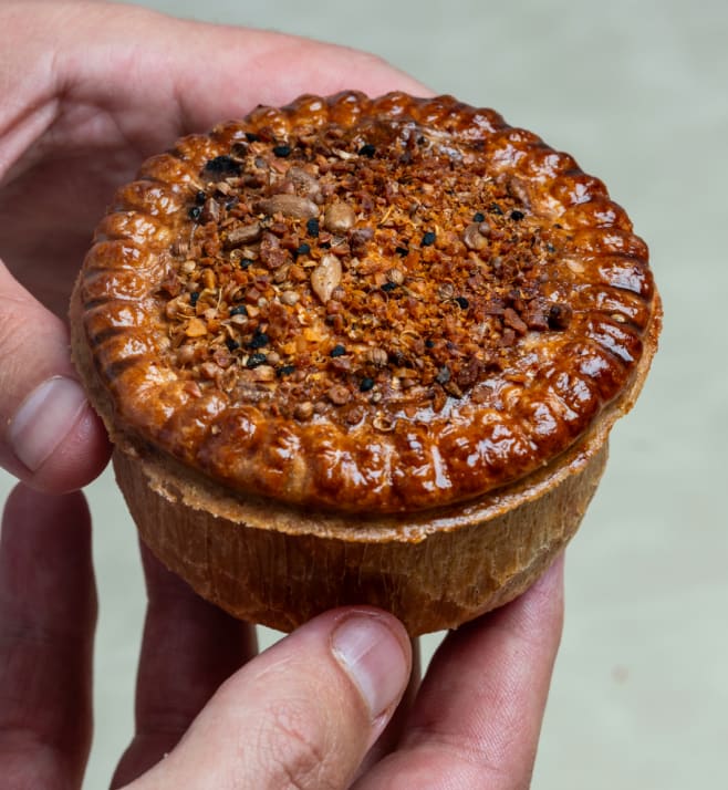 A finished House of Pies pie held in two hands