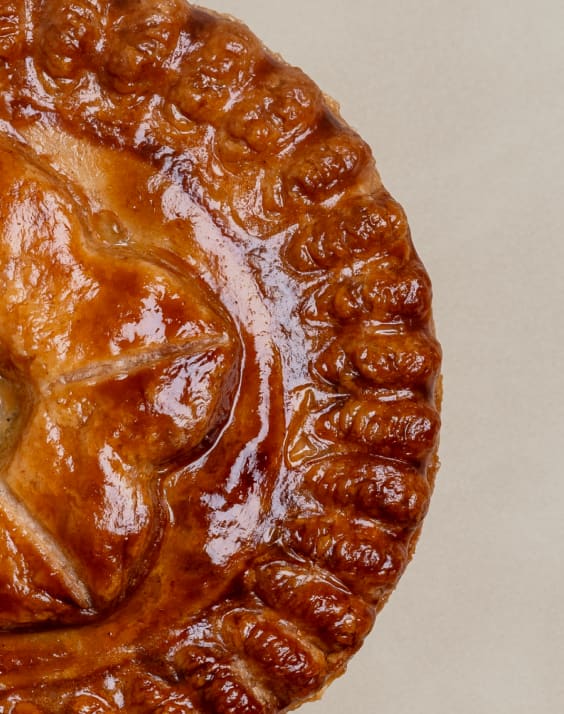 Close-up of a baked pie showing its structured pastry